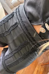Short de cuero ovino negro con bordados y volados en el ruedo.