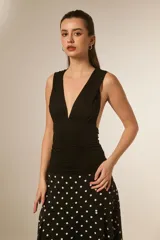 Top sin mangas color negro, ajustado al cuerpo, con escote pronunciado en V y frunces en el busto.