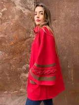 Saco tipo capa de tejido de punto fino en lana color rojo, con detalles de cintas tejidas y trenza en color marrón en las mangas. Talle único.
