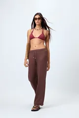 Pantalón de playa tejido calado color crudo, de corte wide leg, cintura elastizada y cordón ajustable.