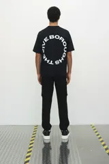 Pantalón jogger negro de felpa pesada de mezcla de algodón, corte slim fit, con cintura elástica ajustable con cordón, cierre decorativo, bolsillos al bies, bolsillo trasero y bolsillos cargo con solapa y botones a presión ocultos en las piernas.