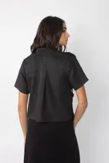 Camisa color crema de lino con pechera de crochet con motivos marinos y mangas cortas.