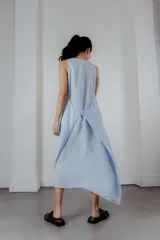 Vestido midi gris oscuro de lino, corte recto y sin mangas. Tiene bolsillos laterales y cuello redondo.