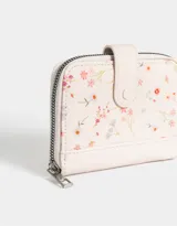 Billetera pequeña de cuerina color crema con estampado de flores pequeñas, cierre perimetral con cremallera y broche con botón a presión.