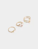 Set de tres anillos dorados con dijes de corazón, luna y strass.