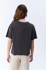 Remera gris oscuro de manga corta con cuello redondo y pinzas laterales que crean un efecto drapeado.