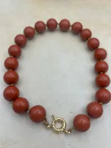 Collar de cuentas redondas de color negro y naranja alternadas.