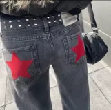 Pantalón de jean gris oscuro con corte recto y bolsillos traseros con apliques de estrellas rojas.