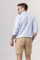 Camisa de hombre color crema, de corte clásico, con cuello abotonado y mangas largas.