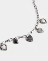 Pulsera plateada con cadena de eslabones gruesos y dijes colgantes de corazones con diferentes diseños.