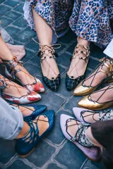 Botines bajos negros con diseño tejido y cordones con borlas. Presentan detalles de animal print en el tobillo y ribete ocre.