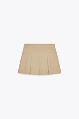 Falda pantalón color beige, de tiro alto, con bolsillos laterales tipo cargo, detalle de tablas y cierre lateral con cremallera oculta y trabilla con hebilla metálica.
