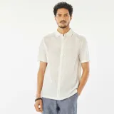 Camisa blanca de manga corta con cuello clásico y estampado de hojas.