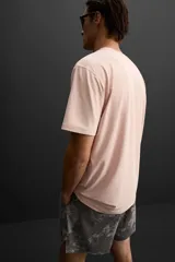 Camiseta deportiva marrón de tejido técnico ligero y elástico con estructura. Cuello redondo, manga corta, costuras planas y logo estampado.