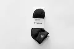 Pack de tres pares de medias soquete unisex, una gris, una negra y una blanca, con logo en el tobillo.