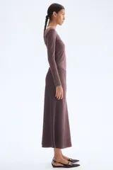 Pollera midi color marrón con leve brillo y caída suave. Modelo de tiro alto con elástico oculto en la cintura y leve vuelo en el bajo.