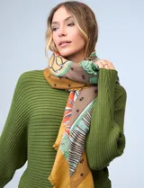 Pashmina rectangular con estampado multicolor en tonos tierra, naranja, verde y amarillo. Presenta motivos geométricos y florales en secciones definidas.