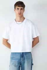 Camiseta blanca de corte boxy, manga corta y cuello redondo.