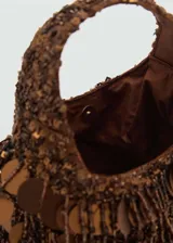 Bolso de mano marrón con flecos y abalorios decorativos.