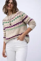 Sweater de lana merino color crema con cuello alto y diseño con motivos geométricos en amarillo, naranja, violeta y negro.