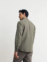 Camisa color ladrillo de lino y algodón, con cuello abotonado, manga 3/4 con puños arremangados, corte clásico y bolsillo de parche en el pecho.