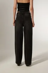 Pantalón jean negro de corte ancho y tiro alto, con bolsillos y apliques de strass en forma de estrella en los laterales.