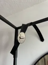 Cinto negro de cuero con hebilla plateada ovalada con diseño de cráneo de toro.