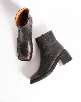 Botas cortas de cuero con estampado de piel de serpiente en tonos grises y negros. Tienen cierre lateral, punta cuadrada y taco bloque de madera color negro.