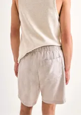 Bermuda verde de tela texturizada con cintura elastizada y cordón de ajuste.