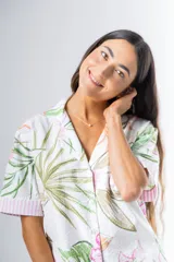 Conjunto de pijama de algodón a rayas verticales rosas y blancas, con detalles en celeste. Incluye camisa de manga corta con botones y bolsillo en el pecho, y shorts con cintura elástica.