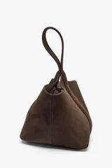 Bolso de mano tipo mini saca de cuero color marrón chocolate. Tiene asa de mano y cierre mediante clip.