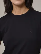 Remera negra de cuello redondo y manga corta con logo pequeño bordado en el pecho.