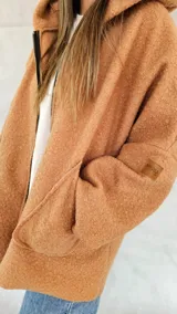 Campera color ocre con capucha y cierre frontal asimétrico.