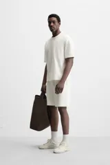 Bermuda negra de corte relaxed fit, con cintura elástica ajustable con cordón, bolsillos frontales y bolsillo trasero de parche.