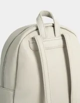 Mochila negra de cuerina con bolsillo frontal con cierre, correas regulables, manija superior, cierre superior y tag de metal.