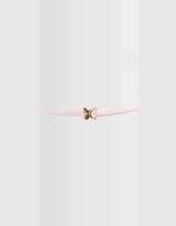 Gargantilla choker de terciopelo rosa con dije de mariposa dorada y cierre de mosquetón.