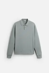 Polo manga larga color gris con cuello solapa y cierre frontal de botonadura.