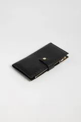 Billetera larga negra con textura tejida y cierre con broche dorado.