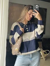 Sweater de hilo de algodón a rayas horizontales rosas y grises, con cuello polo, botones de guampa y bordado de Sierra Mora a tono.