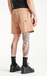 Short de baño color beige, de calce regular, con elástico en la cintura, cordón de ajuste y tres bolsillos.