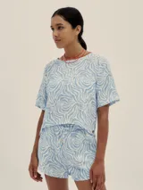 Conjunto de short y remera con estampado abstracto en tonos celeste y blanco. El short tiene pretina con elástico y detalle de Polonio en cobre.
