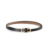Cinto fino de cuero negro con hebilla dorada con forma de doble aro entrelazado.