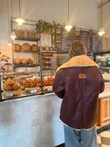 Campera de cuero color marrón con cuello y puños de piel sintética color beige.