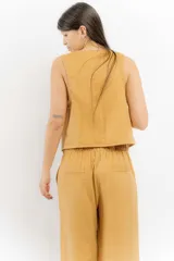 Chaleco marrón de lino con cuello en V y cierre frontal con botones.