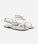 Sandalia plana plateada con tiras finas y detalles de strass, puntera cuadrada y cierre con hebilla en el tobillo.