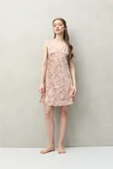 Camisón corto de silueta femenina y liviana, con estampado de hojas en tonos beige y negro. Presenta escote en V con detalle de encaje delicado, breteles finos y regulables, y corte evasé.