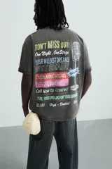 Camiseta negra con efecto lavado, cuello redondo, manga corta y estampado en el frente con la frase "Don't miss out! One Night. One Stage.".