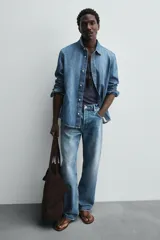 Bolso tipo shopper marrón oscuro, fabricado en cuero con acabado serraje. Tiene un compartimento principal con cierre magnético y un bolsillo interior con cremallera. Cuenta con dos asas de mano de cuero.