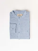 Camisa celeste a rayas verticales, de corte clásico, cuello mao y manga larga. Confeccionada en lino y poliéster.