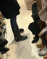 Bota alta de cuero vacuno color negro, con caña recta, punta cuadrada y estribo desmontable.